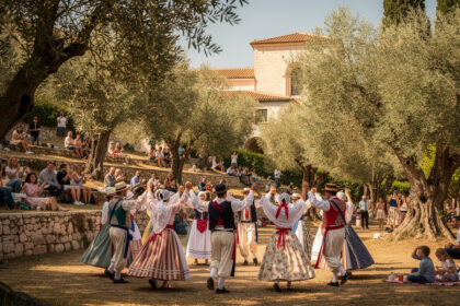 Danseurs en costumes traditionnels niçois lors d'une farandole sous les oliviers des Jardins des Arènes de Cimiez à Nice.
