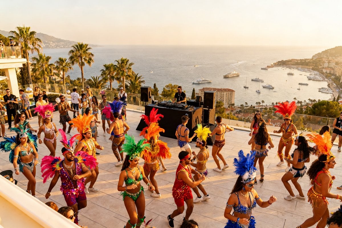 Danseurs en costumes à plumes colorées sur une terrasse dominant la mer au coucher du soleil