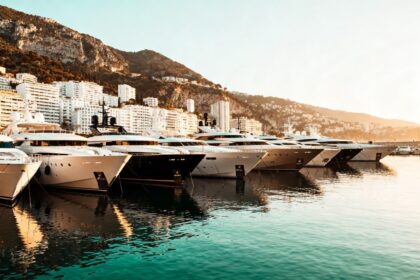 Rangée de superyachts blancs amarrés bord à bord dans un port méditerranéen au coucher du soleil