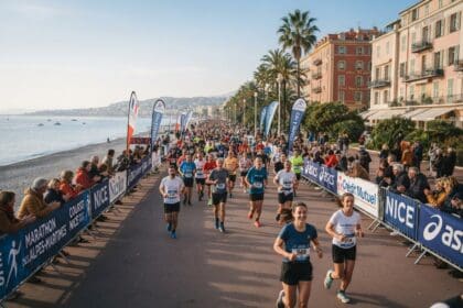 Coureurs avec dossards sur une promenade en bord de mer, entre plage de galets, palmiers et spectateurs derrière des barrières